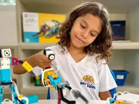 Menina com cabelos cacheados usando uma camiseta branca com o logotipo 